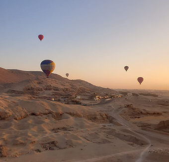 image d'un survol de plusieurs montgolfières à Louxor lors d'un coucher de soleil