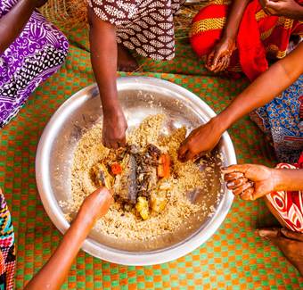 image d'un plat traditionnelle mangé à la main par plusieurs femme autour