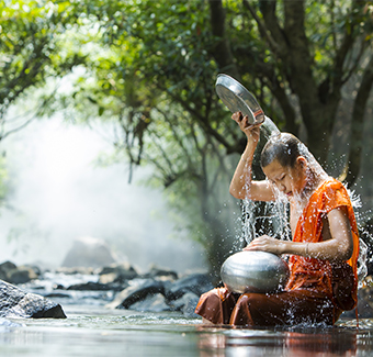image d'un jeune moine se lavant à la rivière
