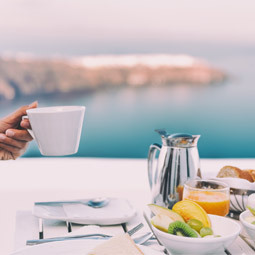 image d'une personne buvant une tasse de café au petit-déjeuner avec un brunch table du restaurant de paquebot de croisière à Santorin