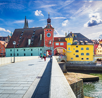 image de la ville Ratisbonne en Allemagne avec son pont de pierre historique et ses bâtiments colorés
