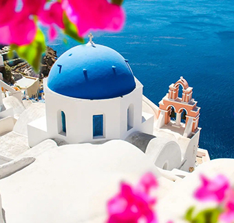 image d'une maison blanche sur l'ile d'Oia avec une coupole en toit bleu devant la mer