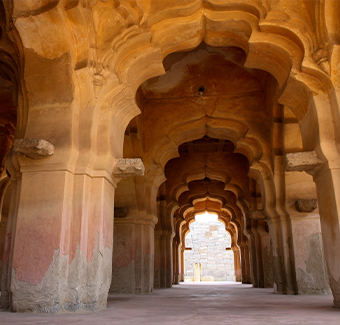 image de sculptures de pierre complexes sur le couloir arqué du palais Lotus Mahal à Hampi