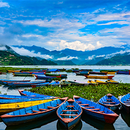 image d'un lac avec comme premier plan plein de petites barques bleues et oranges