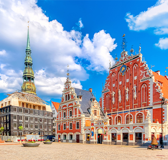 Image de la place de la Vieille Ville Ratslaukums en jour ensoleillé, avec la statue de Roland, la Maison des Têtes Noires et la cathédrale St Peters contre le ciel bleu à Riga en Lettonie