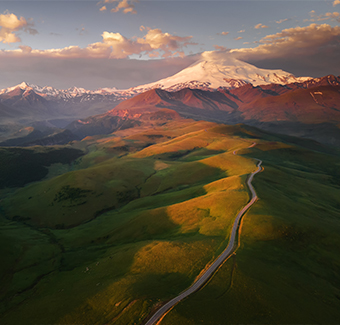 image du Mont d'Elbrouz au lever du soleil avec une route vers la vallée de Gil-Su dans le Nord Caucase
