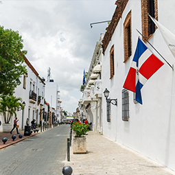 image d'une petite ruelle étroite avec des maisons blanches et le drapeau de la République dominicaine