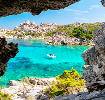 image à partir d'une grotte de l'île d'Asinara avec son eau turquoise et un petit bateau