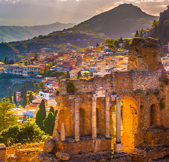 image des ruines du théâtre Taormina et ses maisons aux alentours au coucher du soleil