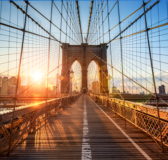 image sur la traversée du pont de Brooklyn à New York lors d'un coucher de soleil