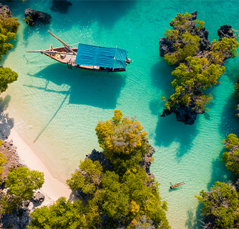 image en vue aérienne de l'île de Pamunda avec une eau turquoise et un bateau en centre