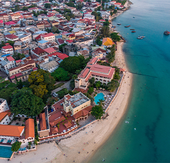 image aérienne de Zanzibar de la plage de Stone Town avec des bateaux de pêcheurs traditionnels de Dhow dans l'océan au coucher du soleil