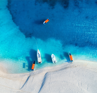 image avec une vue aérienne des yachts et des bateaux de pêche sur la côte tropicale de la mer avec une plage de sable blanc