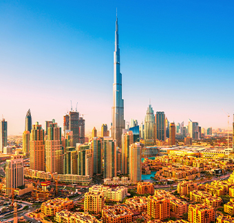 image avec une vue aérienne des toits du centre de Dubaï avec un ciel en dégradé en fond rose et bleu