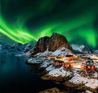 image d'une aurore boréale verte surplombant une petite ville neigeuse avec des habitations traditionnelles entouré d'un lac et de montagnes