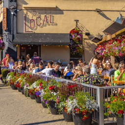 image d'une brasserie local où plusieurs clients profitent du beau temps en bord de terrasse accompagné d'un repas