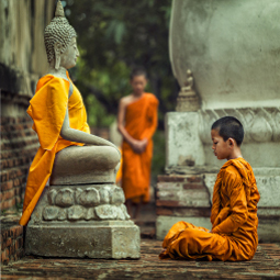 jeune garçon en tenue traditionnelle implorant un Budha